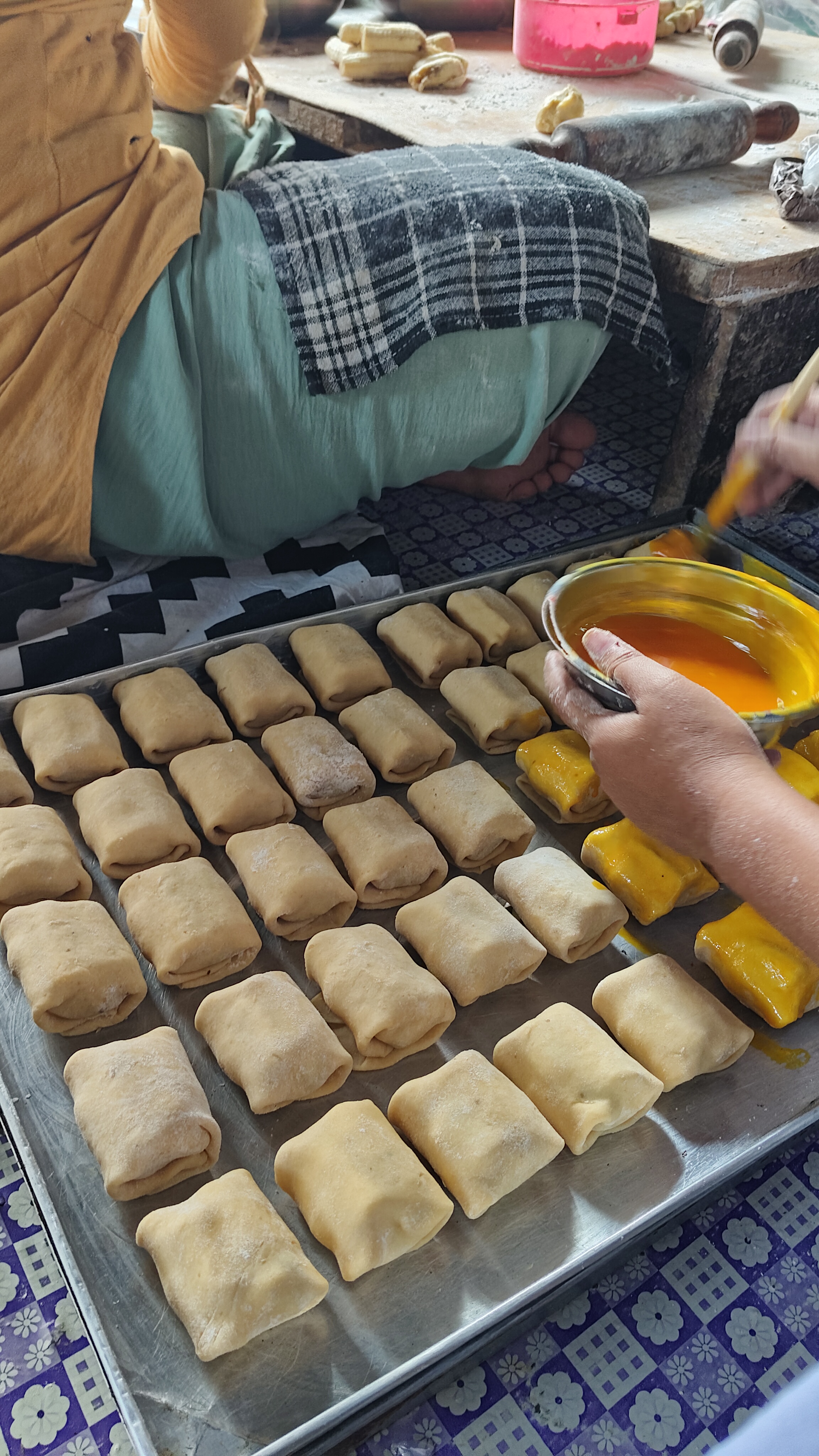 Proses pengolesan kuning telur pada bolen